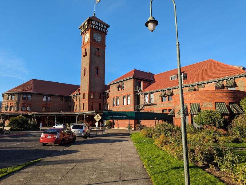 Portland Union Station from outside: a red brick single-story building with vaulted roof and a tall clock tower