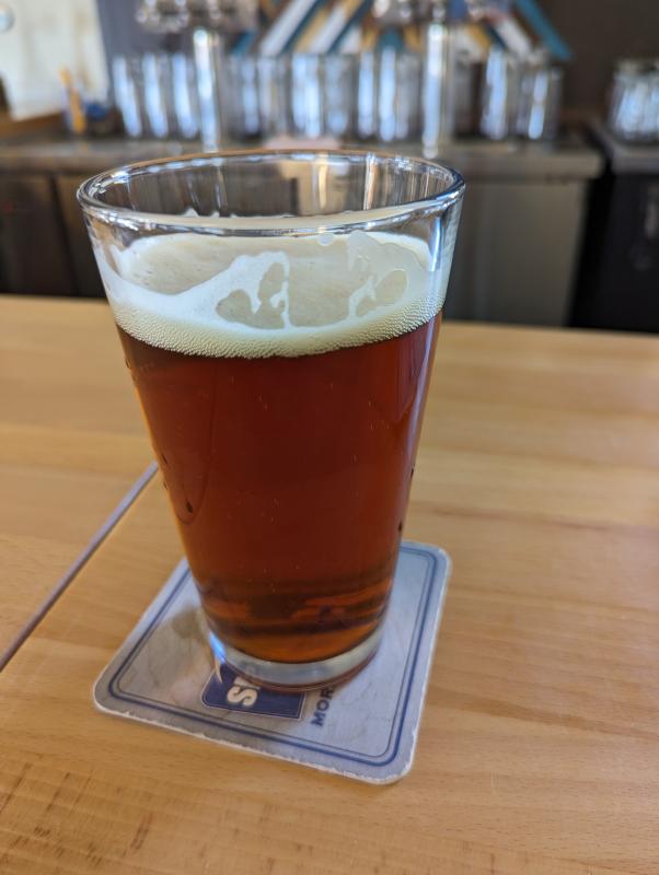 A glass of beer on a wooden bartop