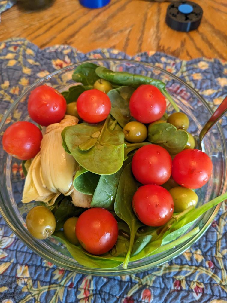 Spinach, tomatoes, artichokes, and olives in a bowl